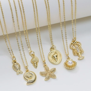 Detailed macro view of golden ocean necklaces featuring shells, starfish, and pearls