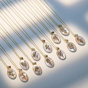 Gold plated brass necklace set with mother of pearl flower pendants and birthstones