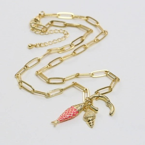 Gold paperclip chain necklace with pink enamel fish and spiral seashell charms on white background