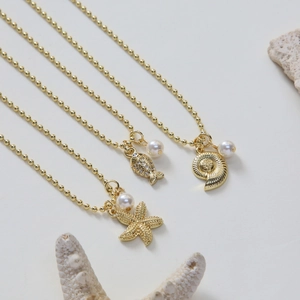 Golden summer beach necklace featuring starfish and sea shell pendants with pearls