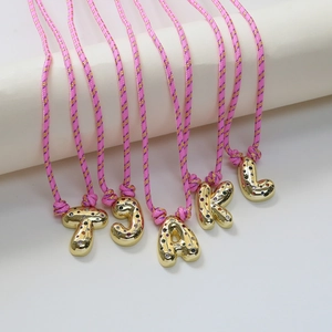 Adjustable woven letter necklace with gold puffy initial pendants and colorful rhinestones