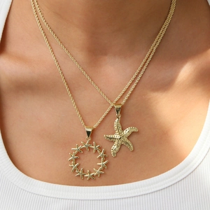 Collier double chaîne avec pendentifs étoile de mer dorés aux détails de textures marines