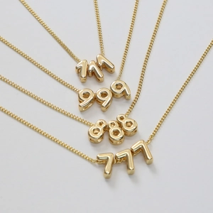 Détail des colliers numéros d'ange plaqués or 18 carats avec pendentifs 111, 777, 888, 999