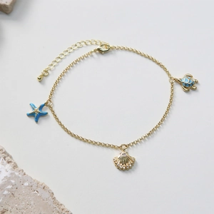 Ocean theme gold anklet with blue starfish, sparkling shell and sea turtle charms