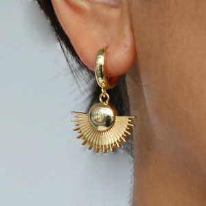 Boucles d'oreilles soleil doré en laiton avec fini poli sur un mannequin féminin