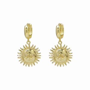 Vue détaillée de boucles d'oreilles soleil dorées avec rayons et yeux en zircone