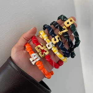 Detailed view of colorful woven paracord sports bracelets with numbered metal charms