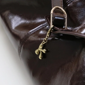 Sac à main en cuir marron foncé avec un porte-clés doré brillant en forme de lettre K