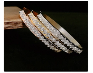 Détail de bracelets joncs à motif vagues sertis de cristaux en or, or rose et argent