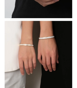 Close-up of minimalist 18K gold plated titanium bangles with sparkling zircon inlay
