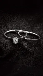 Detalle del conjunto de joyas de titanio con anillo de diamante y banda minimalista