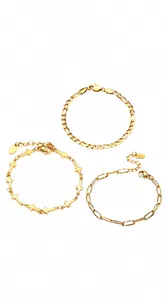 Detailed view of three 18K gold plated titanium bracelets with cross and lobster clasp