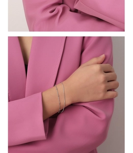Detalle de pulsera de doble capa plateada con cadena de serpiente en la muñeca