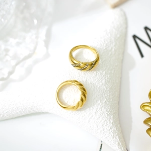 Twisted rope gold rings set with rhinestone inlay on white starfish decorative prop