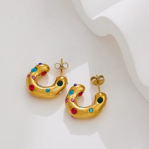 Detail of 18k gold plated U-shaped chunky earrings with colorful inlaid zircons on tray