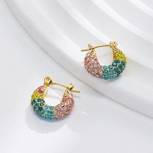 Macro detail of 18k gold earrings featuring colorful pavé crystals on a white display