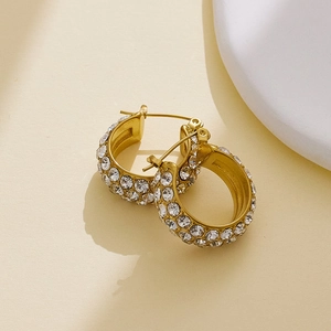 Macro shot of gold-plated hoop earrings featuring multi-row pave-set sparkling cubic zirconia