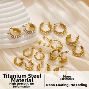 Close-up of 18k gold plated titanium earrings with white pearls on a soft white background