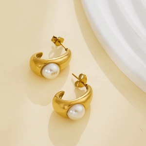 Macro detail of 18k gold plated stainless steel C-shaped earrings with white pearl inlay