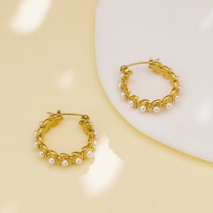 Detail of 18k gold stainless steel hoop earrings with white pearls in leaf settings