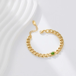 Detail of 18k gold plated Cuban link bracelet with a vivid green zircon gemstone