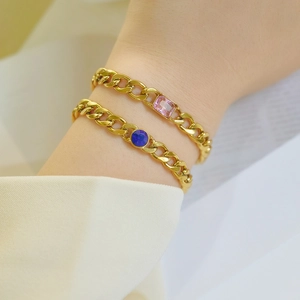 Close-up of 18k gold plated Cuban chain bracelets with pink and blue zircon gemstones