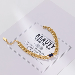 Detail of 18k gold plated Cuban chain bracelet with rectangular blue zircon gemstone