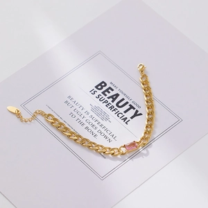 Detail of 18k gold plated Cuban chain bracelet with rectangular pink zircon gemstone