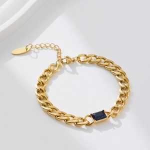 Detail of 18k gold plated curb chain bracelet featuring a rectangular blue zircon stone