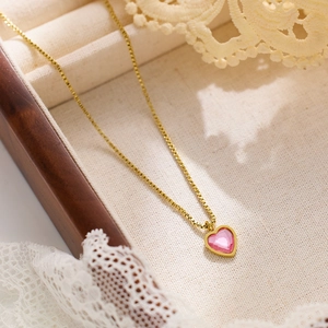 Close-up of heart-shaped pink crystal necklace pendant in a premium wooden gift box
