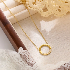 Vue détaillée du collier pendentif cercle doré avec cristaux sur écrin en velours