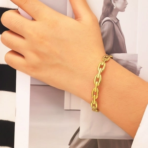 Bracelet à grosse chaîne dorée en acier inoxydable sur un poignet élégant
