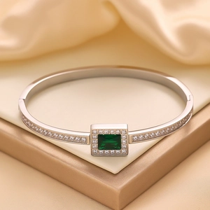 Macro shot of silver stainless steel hinge bracelet with emerald green zircon gemstone