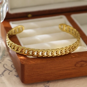 Détail d'un bracelet jonc en acier inoxydable plaqué or 18 carats avec design gourmette