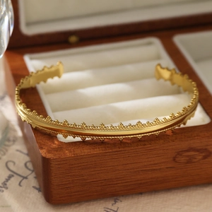 Gros plan d'un bracelet jonc vintage en acier doré 18 carats sur doublure en velours