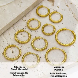 Macro view of gold titanium steel hoop earrings with twisted and hammered textures