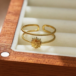Detalle de anillo ajustable de doble capa dorado con estrella en joyero de madera y terciopelo