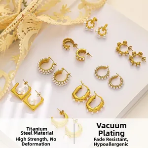 Vue macro des boucles d'oreilles en acier titane avec perles baroques dorées
