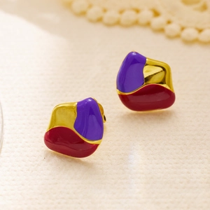Detailed macro view of vintage gold earrings with abstract purple and red enamel