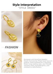 Detailed macro view of triple-layered vacuum plated gold earrings on white fabric
