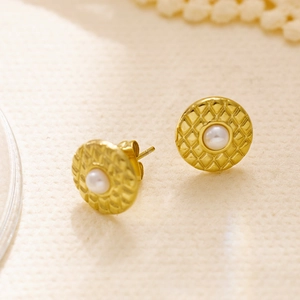 Detailed view of golden rhombus texture earrings with central white round pearl inlay
