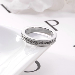 Macro di anello eternity in acciaio argento con zirconi bianchi su ceramica bianca