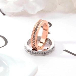 Dettaglio ravvicinato di anelli eternity in oro rosa e argento con cristalli brillanti
