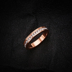 Dettaglio dell'anello in acciaio inossidabile oro rosa con cristalli su pelle nera