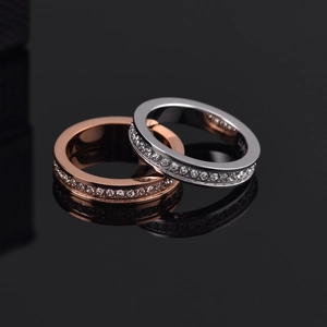 Dettaglio macro di anelli eternity in oro rosa e argento con scintillanti pietre zircone