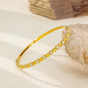 Vue détaillée d'un bracelet doré en acier inoxydable serti de zircons brillants