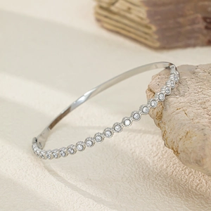Gros plan sur un bracelet en acier titane argenté orné de zircons ronds sertis pavé