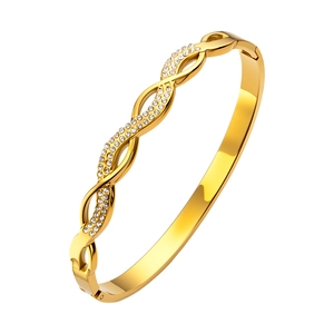 Primer plano de brazalete trenzado bañado en oro de 18K con detalles de circonitas