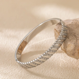 Gros plan détaillé d'un bracelet en acier argenté avec rainures ornées de cristaux