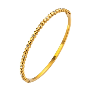 Detalle del brazalete de acero de titanio chapado en oro 18K con estrellas de circón